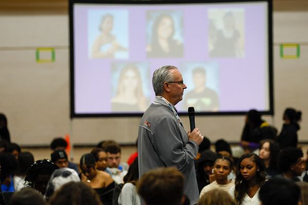 Mike Lutzenkirchen, the featured speaker from the Lutzie 43 Foundation, addressed hundreds of students gathered in the gym at Lakeside High on Tuesday, March 26, 2024. He offered advice on driving safety as he walked in front of a screen showing the five students who tragically died in car accidents this school year. (Miguel Martinez /miguel.martinezjimenez@ajc.com)