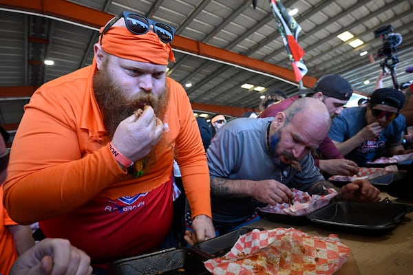 James Gordon, left, of DeLand, Fla., and Chris Green, second from left, compete in the Eat the (Pork) Butt Challenge during the Florida Man Games, Saturday, March 1, 2025, in Elkton, Fla. (AP Photo/Phelan M. Ebenhack)