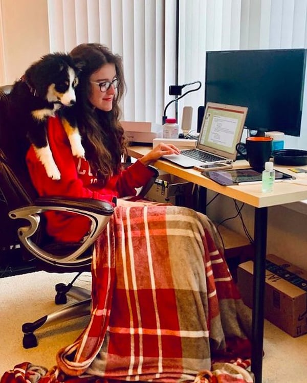 Morehouse School of Medicine student Anastasia Kolousek does some digital learning as her dog Mishti watches. CONTRIBUTED