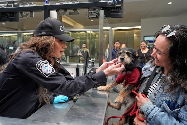 Homeland Security Secretary Kristi Noem, left, greets Jessica Medina and her dog Luna during a tour of the San Ysidro Port of Entry, Sunday, March 16, 2025, in San Diego. (AP Photo/Alex Brandon)