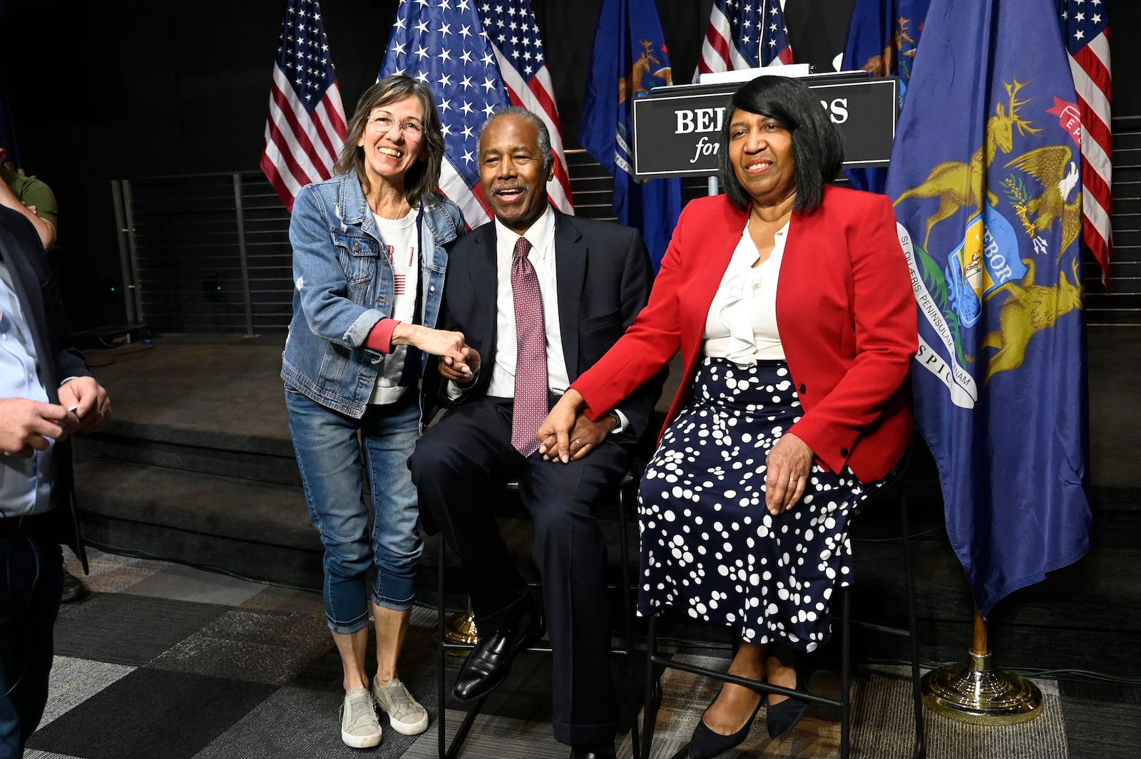 =Ben Carson, center, and his wife Candy Carson, right, pose for a photo with Tracy Campbell following his address to supporters of Republican presidential nominee former President Donald Trump, Saturday, Oct. 5, 2024, in Livonia, Mich. (AP Photo/Jose Juarez)