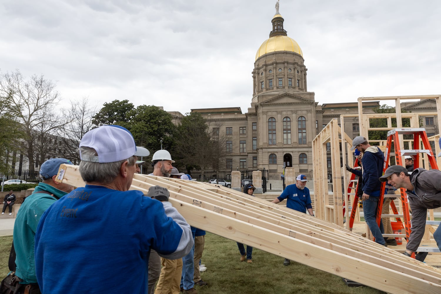 Habitat for Humanity volunteers take down the frame of a home built at Liberty Plaza, outside the Capitol, in Atlanta on Wednesday, March 5, 2025. The frame will be transported and used to house a family. (Arvin Temkar / AJC)