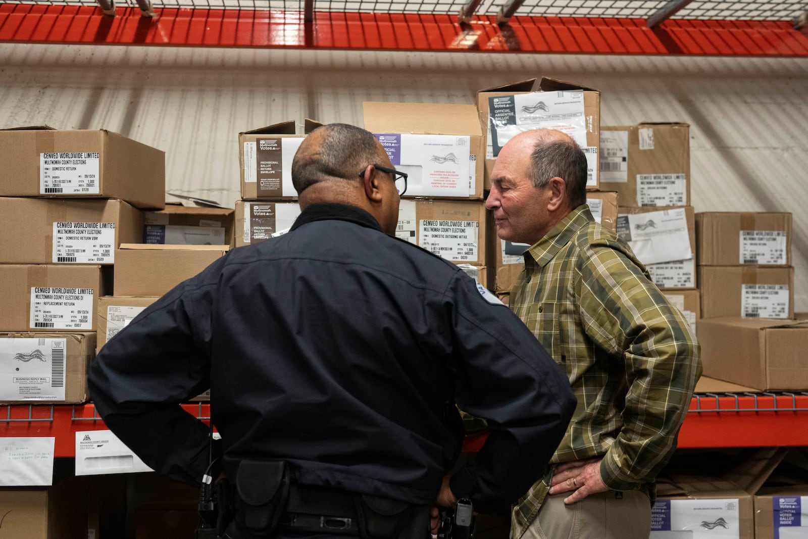 Assistant Chief of Police for the Vancouver Police Department Troy Price, left, talks with Greg Kimsey, the longtime elected auditor in Clark County, Wash., after a news conference at the Multnomah County Elections Division office on Monday, Oct. 28, 2024, in Portland, Ore. (AP Photo/Jenny Kane)