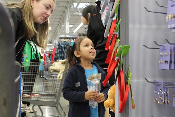 Samara Ayla, 5, picks out the jewelry she wants with her mentor Aggie Hahn in Walmart on Nov. 10, 2024 in Athens, Georgia. The Shop with a Bulldawg event day allows children like Ayla to shop for gifts for themselves during the holiday season. (Photo Courtesy of Rachel Sandstrom)