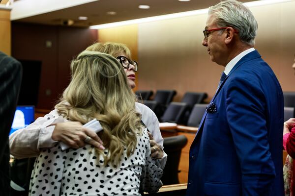 Supporters of Diane McIver embrace inside a Fulton County Courtroom after her husband, Tex, was denied bond on Friday, October 7, 2022. (Natrice Miller/natrice.miller@ajc.com)  