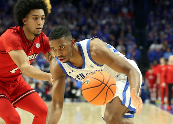 Kentucky's Lamont Butler, right, is pressured by Louisville's Chucky Hepburn, left, during the second half of an NCAA college basketball game in Lexington, Ky., Saturday, Dec. 14, 2024. (AP Photo/James Crisp)