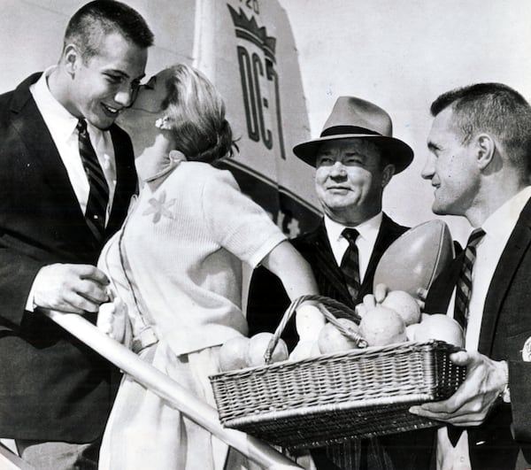 Pat Dye gats a kiss from Orange Bowl Queen Nancy Wakefield. Coach Wally Butts (C) and Jimmy Vickers watch the ceremony as the SEC champion Bulldogs were welcomed to Miami for the Orange  Bowl game against Missouri in 1959. (AP)