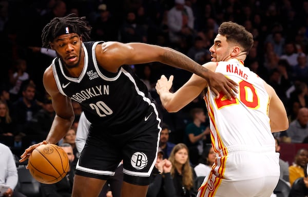 Brooklyn Nets center Day'Ron Sharpe (20) drives to the basket against Atlanta Hawks forward Georges Niang (20) during the first half of an NBA basketball game, Sunday, March 16, 2025, in New York. (AP Photo/Noah K. Murray)