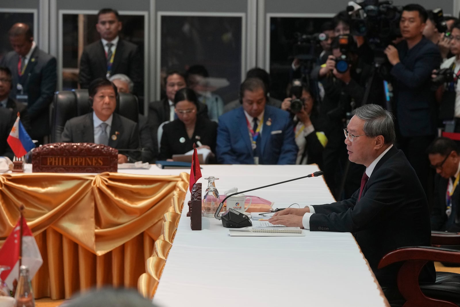 Chinese Premier Li Qiang, right, delivers his opening remarks as Philippine's President Ferdinand Marcos Jr., front left, listens during the 27th Association of Southeast Asian Nations (ASEAN)-China Summit in Vientiane, Laos, Thursday, Oct. 10, 2024. (AP Photo/Dita Alangkara)