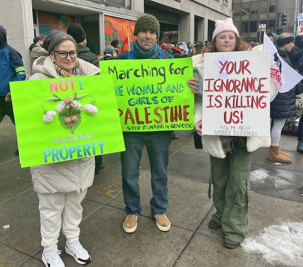 Griffin resident Sarah Sheehan (right) flew into Washington and met up with her mother and her mother's co-worker to attend the People's March. Sheehan's sign highlighted the story of Amber Thurman, a Georgia woman who died after complications from a medical abortion. Tia Mitchell/AJC