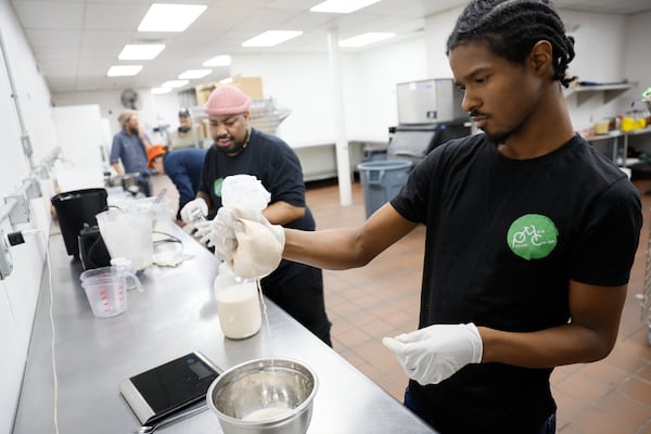 Nijil Jones works filtering the pecan milk while Antonio Little prepares the containers for the handmade pecan milk; they are part of a cooperative where six employees are owners of the company.
Thursday, April 13, 2023.

Miguel Martinez /miguel.martinezjimenez@ajc.com