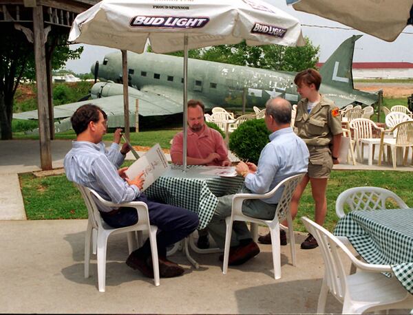  An old DC-3 can be seen behind patio diners at the 57th Fighter Group Restaurant. / AJC file photo