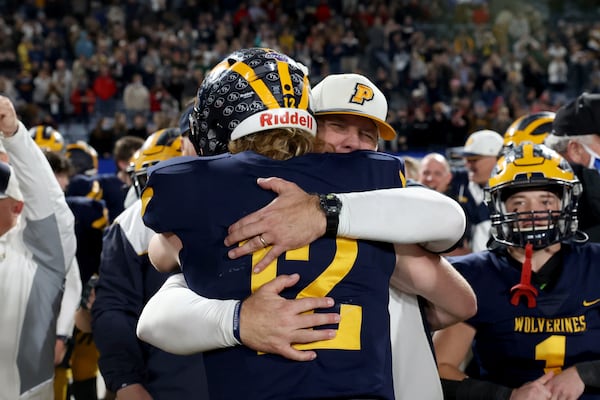 Prince Avenue Christian coach Greg Vandagriff, facing, celebrates with his son and quarterback Brock Vandagriff (12) after their 41-21 win against Trinity Christian during the Class 1A Private championship at Center Parc Stadium Monday, December 28, 2020 in Atlanta, Ga.. JASON GETZ FOR THE ATLANTA JOURNAL-CONSTITUTION



