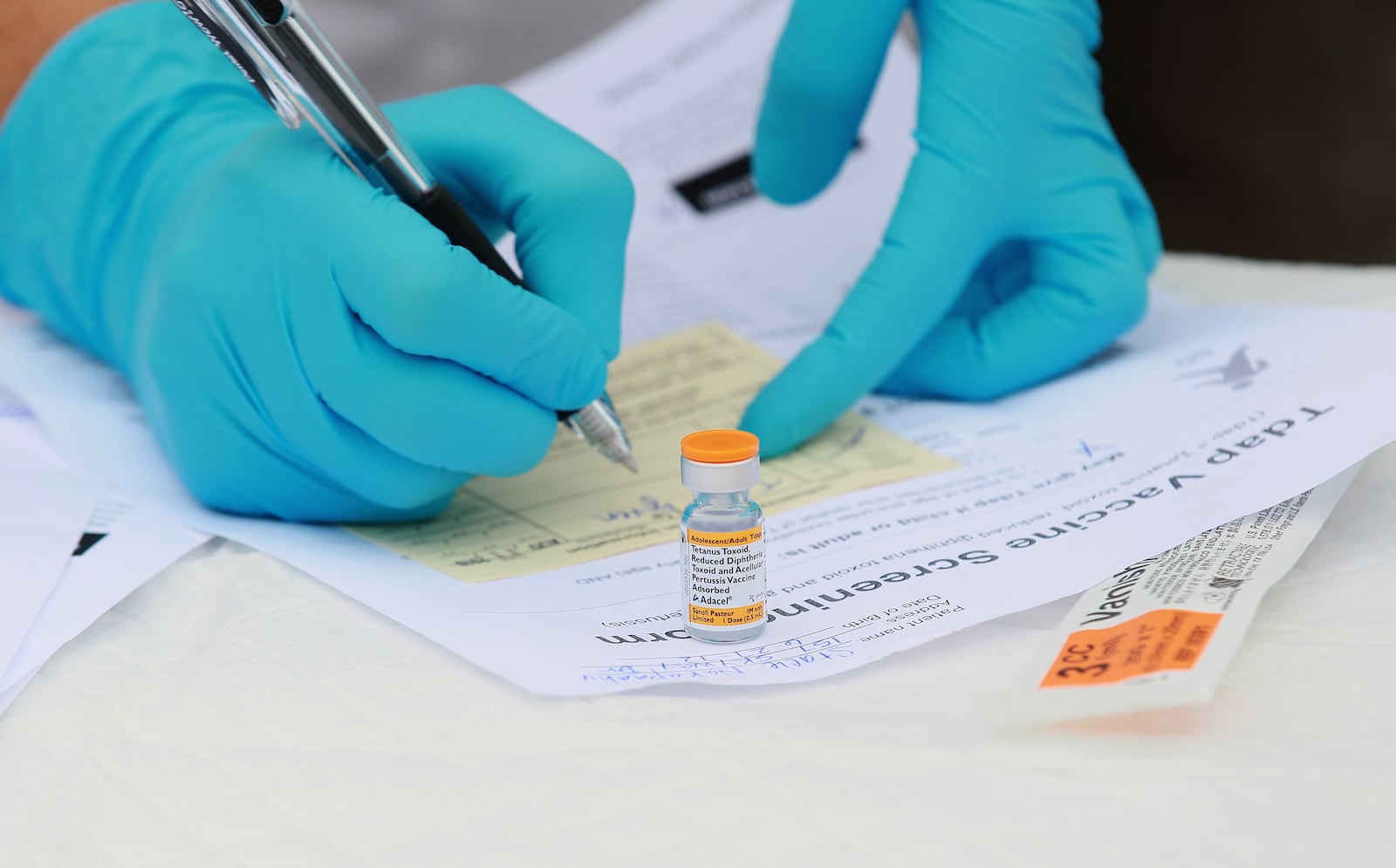 In this file photo,  Touro University medical student Shamis Fallah prepares paperwork before adminstering a Tdap vaccination during the Solano County health fair August 11, 2010 in Vallejo, California.  (Photo by Justin Sullivan/Getty Images)