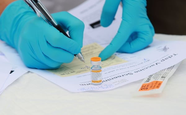 In this file photo,  Touro University medical student Shamis Fallah prepares paperwork before adminstering a Tdap vaccination during the Solano County health fair August 11, 2010 in Vallejo, California.  (Photo by Justin Sullivan/Getty Images)