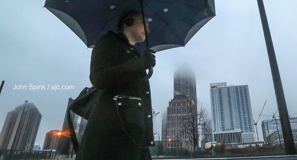 Kristin Galvin made her way down 14th Street early Friday morning as rain moved through the city.