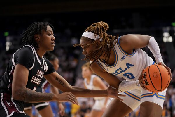 UCLA forward Janiah Barker (0) drives against South Carolina forward Ashlyn Watkins during the second half of an NCAA college basketball game, Sunday, Nov. 24, 2024, in Los Angeles. (AP Photo/Eric Thayer)