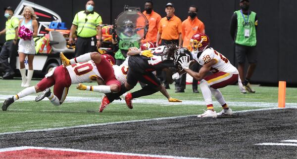 Falcons running back Cordarrelle Patterson bears down to reach the end zone against three defenders to take a 17-13 lead over the Washington Football Team during the final minute of the second quarter Sunday, Oct. 3, 2021, at Mercedes-Benz Stadium in Atlanta.   (Curtis Compton / Curtis.Compton@ajc.com)