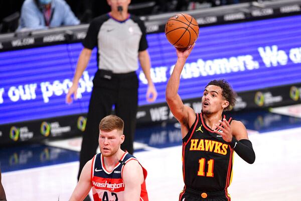 Atlanta Hawks guard Trae Young (11) shoots over Washington Wizards forward Davis Bertans (42) during the first half of an NBA basketball game, Friday, Jan. 29, 2021, in Washington. (AP Photo/Nick Wass)