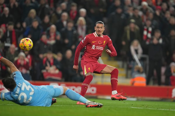 Liverpool's Darwin Nunez, right, scores his side's first goal against Aston Villa's goalkeeper Emiliano Martinez during the English Premier League soccer match at the Anfield stadium in Liverpool, Saturday, Nov. 9, 2024. (AP Photo/Jon Super)