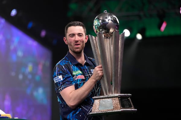 FILE - Luke Humphries of England poses with the trophy after winning the final match against Luke Littler of England at the World Darts Championship, in London, Wednesday, Jan. 3, 2024. (AP Photo/Kin Cheung, File)