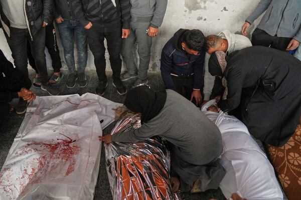 Members of the Abu Aker mourn over the bodies of their relatives killed during an Israeli army strike, before their burial at the Baptist hospital in Gaza City, Monday March 24, 2025.(AP Photo/Jehad Alshrafi)