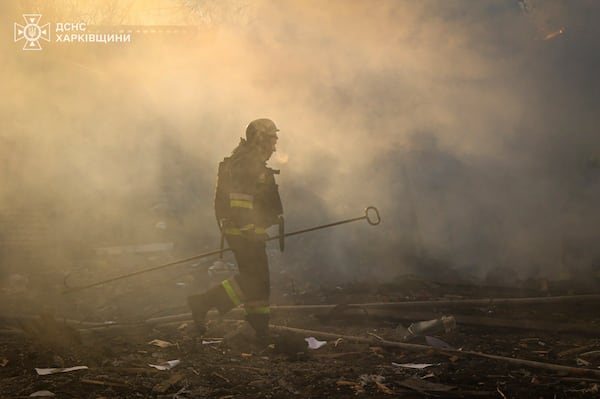 In this photo provided by the Ukrainian Emergency Service, a firefighter works to extinguish the fire following a Russian rocket attack in Kharkiv, Ukraine, Friday, March 7, 2025. (Ukrainian Emergency Service via AP)