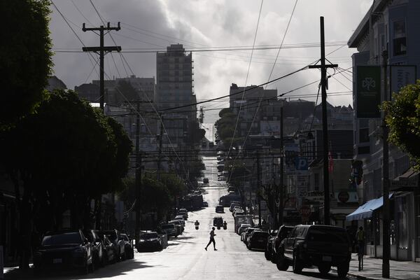 A person crosses a street during a break in rain Saturday, Nov. 23, 2024, in San Francisco. (AP Photo/Andy Bao)