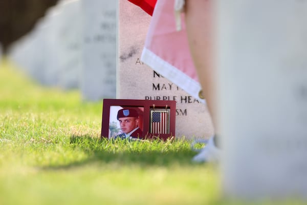 A photograph of the late SCP Ryan C. King lays in front of his grave, Thursday, May 12, 2022. King served in Afghanistan during Operation Enduring Freedom and was killed on May 1, 2009. (Miguel Martinez / miguel.martinezjimenez@ajc.com)