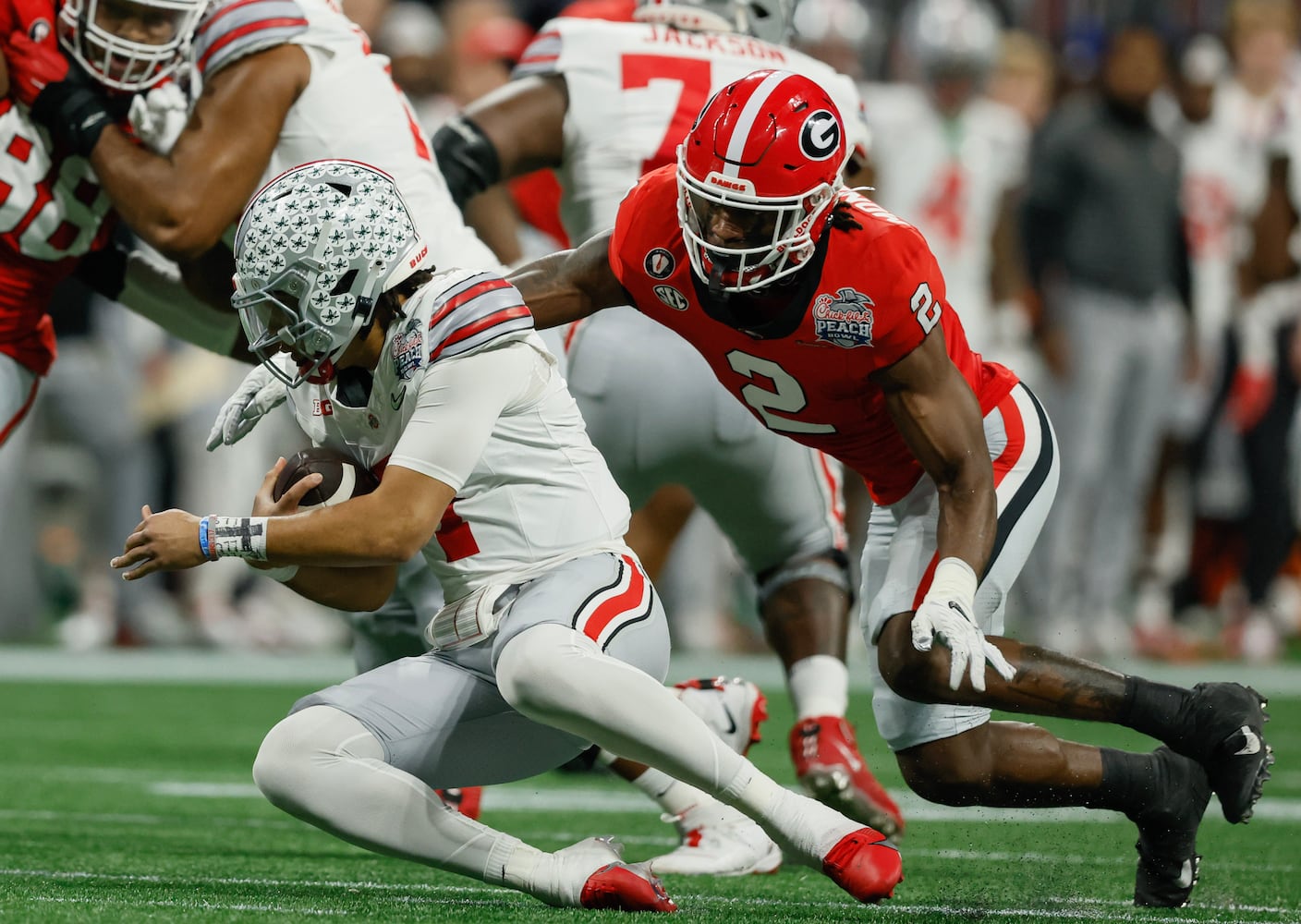 Georgia Bulldogs linebacker Smael Mondon Jr. (2) sacks Ohio State Buckeyes quarterback C.J. Stroud (7) for a loss during the first quarter of the College Football Playoff Semifinal between the Georgia Bulldogs and the Ohio State Buckeyes at the Chick-fil-A Peach Bowl In Atlanta on Saturday, Dec. 31, 2022. (Jason Getz / Jason.Getz@ajc.com)