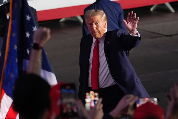 Republican presidential nominee former President Donald Trump waves as he departs a campaign rally at Van Andel Arena, Tuesday, Nov. 5, 2024, in Grand Rapids, Mich. (AP Photo/Paul Sancya)