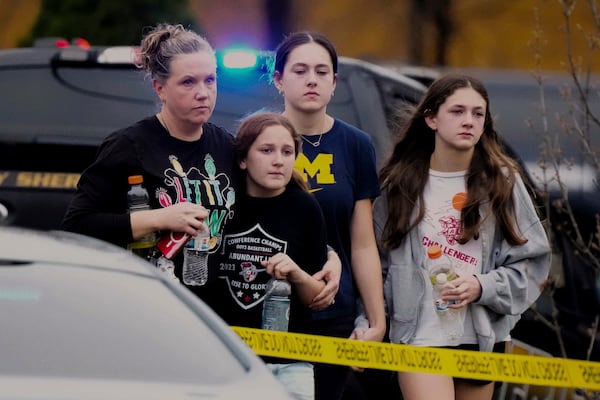 A family leave the shelter after multiple injuries were reported following a shooting at the Abundant Life Christian School, Monday, Dec. 16, 2024. (AP Photo/Morry Gash)