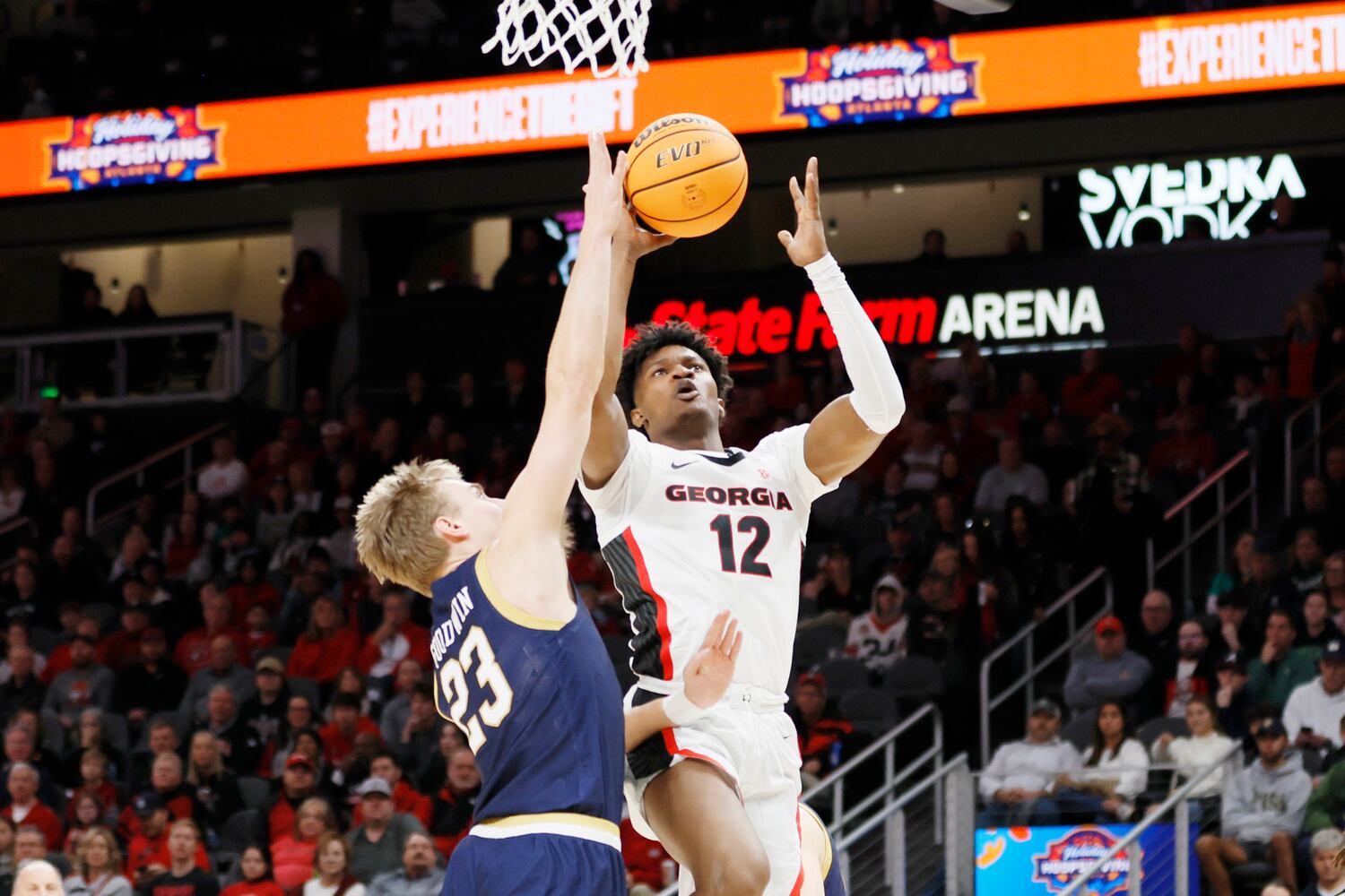 Bulldogs forward Matthew-Alexander Moncrieffe shoots over Fighting Irish guard Dane Goodwin during the first half Sunday night at State Farm Arena. (Miguel Martinez / miguel.martinezjimenez@ajc.com)