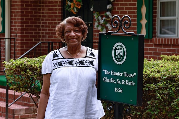 Mary Hunter Mullins, daughter of Charlie Hunter Sr. stands next to the marker placed in front of his home. The house is the first in a historic Black neighborhood to receive a home marker. (Natrice Miller/natrice.miller@ajc.com)