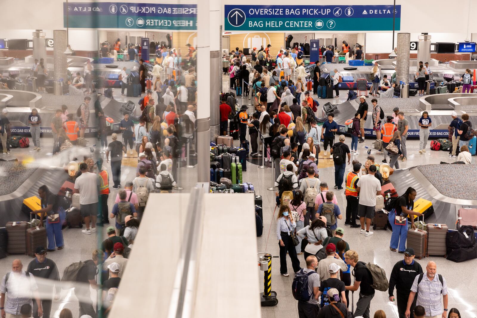 Travelers line up at a baggage help center at Hartsfield-Jackson airport domestic terminal late in the evening in Atlanta on Saturday, July 20, following a global technology outage that has hampered airlines and other industries. (Arvin Temkar / AJC)