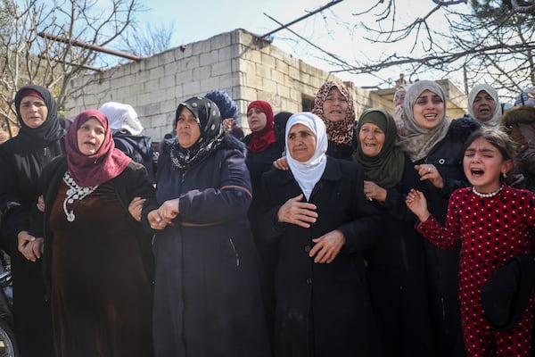 Relatives and neighbours mourn during the funeral procession for four Syrian security force members killed in clashes with loyalists of ousted President Bashar Assad in coastal Syria, in the village of Al-Janoudiya, west of Idlib, Saturday, March 8, 2025. (AP Photo/Omar Albam)