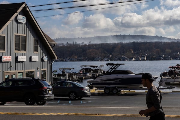 Smoke rises from a wildfire in a forested mountain area across from Greenwood Lake, Monday, Nov. 11, 2024, in Lakeside, New Jersey. (AP Photo/Stefan Jeremiah)