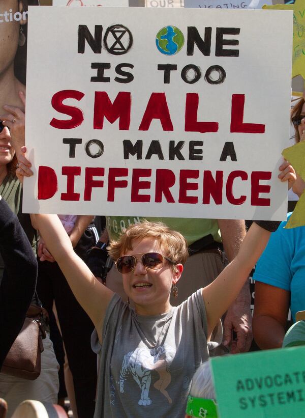 People hold signs as they march by the Capitol during the Climate Reality Strike March Friday, September 20, 2019. STEVE SCHAEFER / SPECIAL TO THE AJC