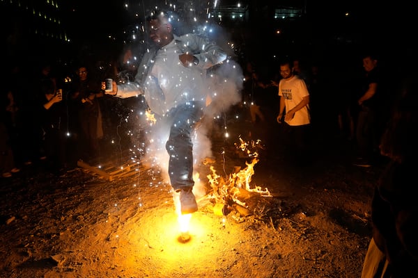 An Iranian man jumps over a firework celebrating Chaharshanbe Souri, or Wednesday Feast, an ancient Festival of Fire on the eve of the last Wednesday of the Persian year, in Tehran, Iran, Tuesday, March 18, 2025. Iranians celebrate their new year, or Nowruz, with arrival of the spring. (AP Photo/Vahid Salemi)