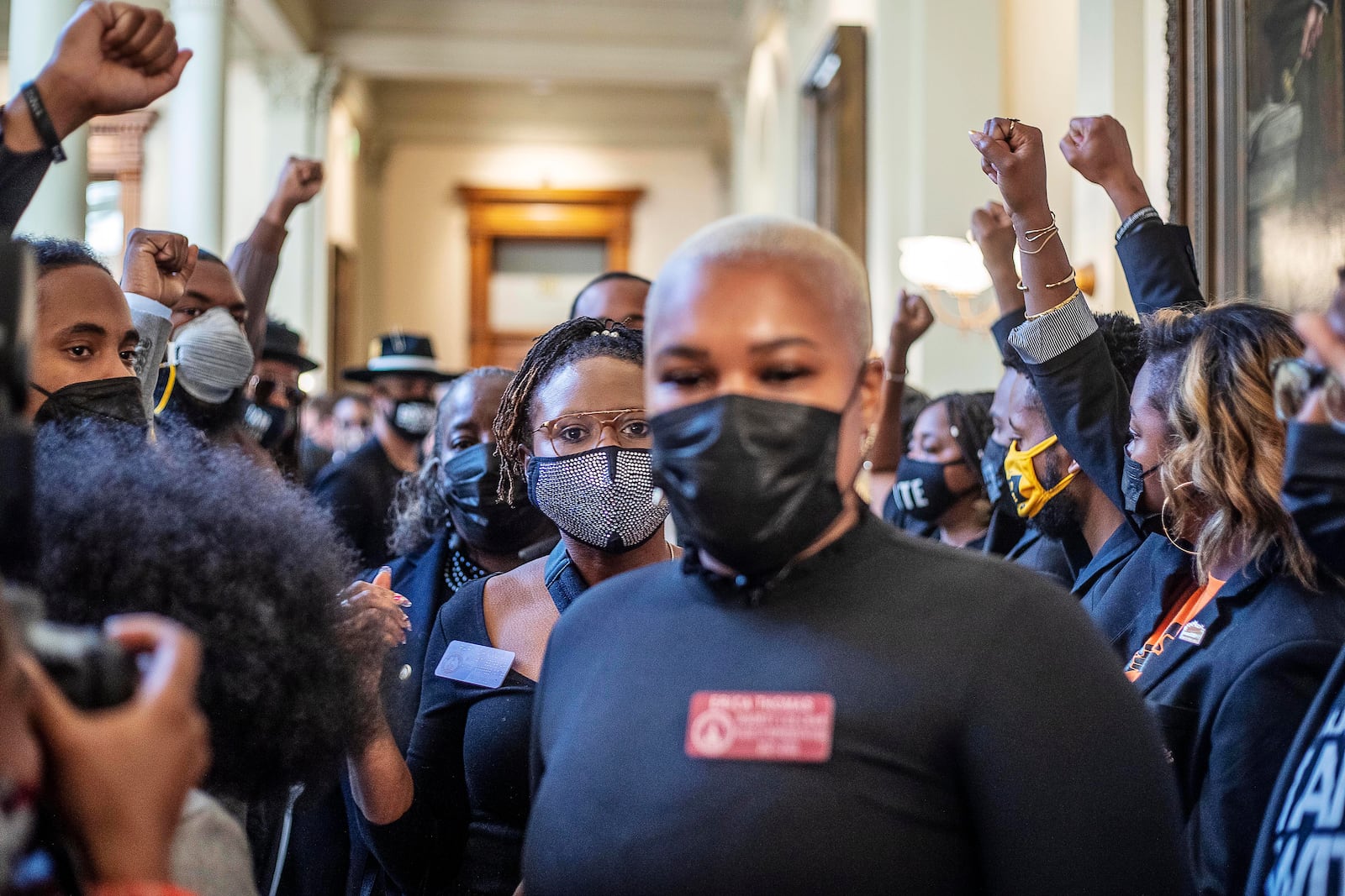 Supporters surround Democratic state Rep. Park Cannon, center, as state Rep. Erica Thomas, foreground, escorts her into the House chambers at the Georgia Capitol. (Alyssa Pointer / Alyssa.Pointer@ajc.com)