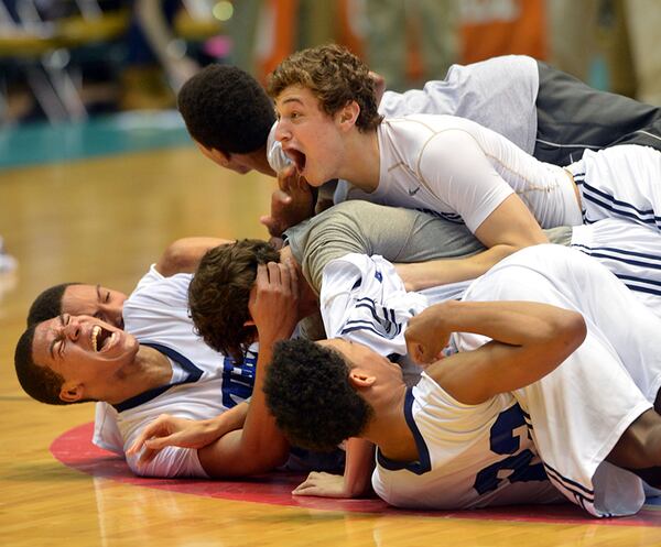 MARCH 8, 2014 MACON St Francis Knights players celebrate their win after the game. Coverage of the Class A Private boys basketball championship between the Whitefield Academy Wolfpack Warriors and St Francis Knights at the Macon Coliseum Saturday, March 8, 2014. St Francis Knights won, beating the Whitefield Academy Wolfpack 65-60. KENT D. JOHNSON / KDJOHNSON@AJC.COM St. Francis players pile up on the court after their Class A Private championship win over Whitefield Academy Saturday, March 8, 2014, in Macon. (Kent D. Johnson / AJC)