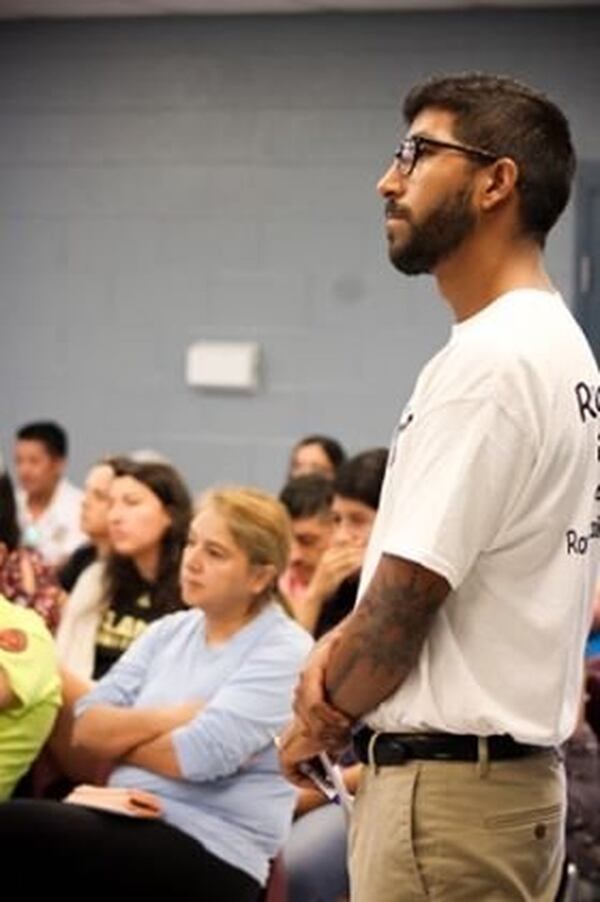 Christian Limon listens intently to an immigration attorney speak during a “Know Your Rights Immigration Forum” hosted by Romanos Unidos, the organization he helped found. Limon was born here, but he wants to help those who weren’t. CONTRIBUTED