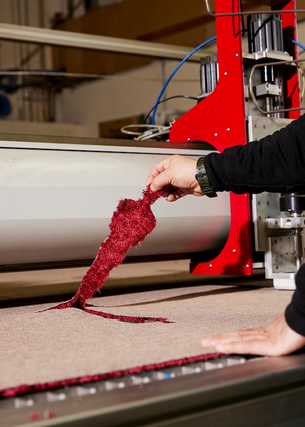 
                        The statuette inlays are created using a high-pressure stream of water, akin to a needle, that makes the cuts according to a computer program at a warehouse in La Mirada, Calif., on Feb. 21, 2025. Steve Olive, who has worked in the event carpet business for more than three decades, is the man the Academy trusts to get its iconic rug just right. (Jennelle Fong/The New York Times)
                      