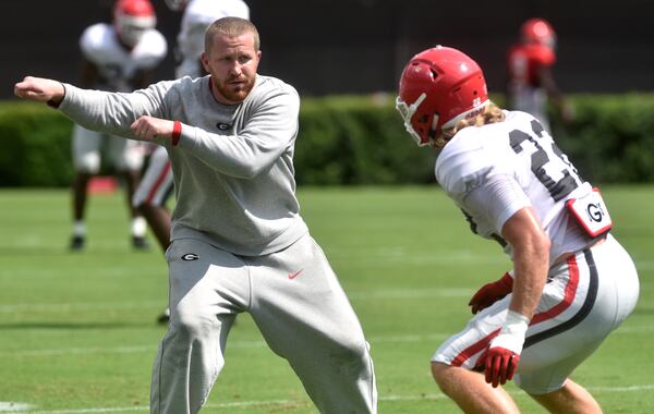 Georgia inside linebackers coach Glenn Schumann leads a player  through a drill. (RICHARD HAMM / Special to the AJC)