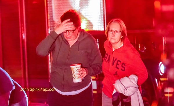 Family members grieve after a woman was killed in a DeKalb County home fire. JOHN SPINK / JSPINK@AJC.COM