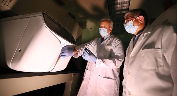 Project manager John Nechtman, left, and director Jin-Xiong She, right, work with a newly installed Ion Gene Studio S5 Prime Semiconductor Sequencer in the genomics core laboratory at Augusta University Medical Center. (Curtis Compton / Curtis.Compton@ajc.com)