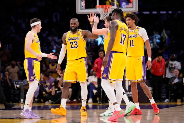 Los Angeles Lakers guard Luka Doncic, center, is congratulated after scoring by forward LeBron James, second from left, guard Austin Reaves, left, forward Dorian Finney-Smith, forward Dorian Finney-Smith, second from right, and center Jaxson Hayes during the second half of an NBA basketball game against the Minnesota Timberwolves, Thursday, Feb. 27, 2025, in Los Angeles. (AP Photo/Mark J. Terrill)