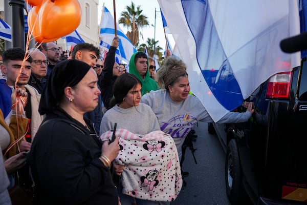 Mourners react as the convoy carrying the coffins of slain hostages Shiri Bibas and her two children, Ariel and Kfir, passes by during their funeral procession in Rishon Lezion, Israel, Wednesday, Feb. 26, 2025. The mother and her two children were abducted by Hamas on Oct. 7, 2023, and their remains were returned from Gaza to Israel last week as part of a ceasefire agreement with Hamas. (AP Photo/Ariel Schalit)