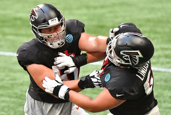 Falcons center Alex Mack (51) and guard Chris Lindstrom (63) run a drill during an NFL football training camp practice at Mercedes-Benz Stadium on Thursday, September 3, 2020. (Hyosub Shin / Hyosub.Shin@ajc.com)