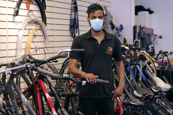 In this Wednesday, June 24, 2020, photograph, Noah Hicks, owner of Spokehouse Bikes in the Upham's Corner neighborhood of Boston, poses at his shop. Many from outside Boston have donated to and shopped at the store which was robbed and vandalized earlier in the month.